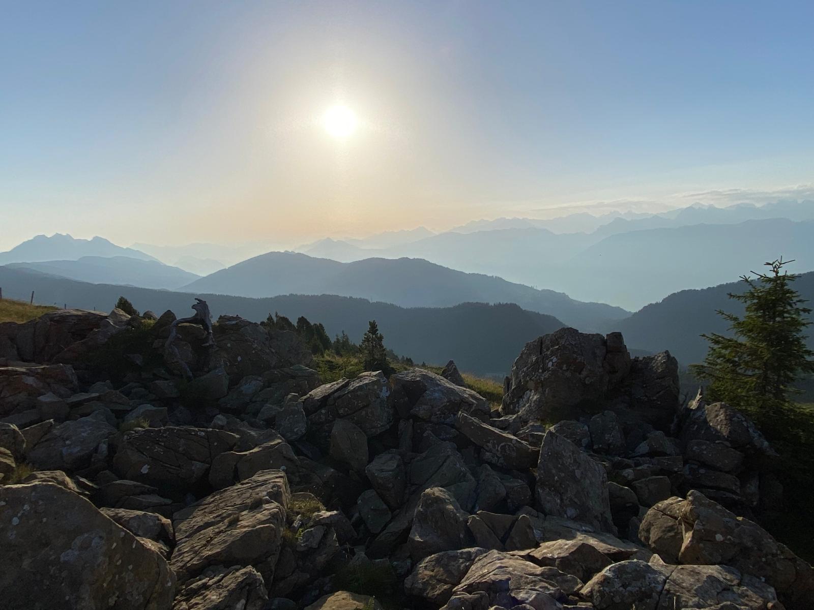 Rickhubel im warmen Sonnenlicht des frühen Morgens mit kühlen Bergkonturen der Zentralschweiz im Hintergrund