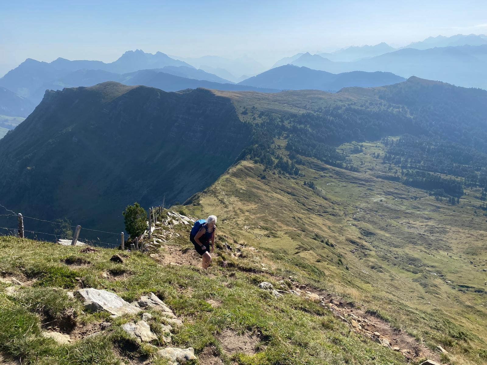 Elisabeth beim Aufstieg zum Fürstein, im Hintergrund umrissartig der Pilatus und die Zentralschweizer Berge im blauen Morgenlicht